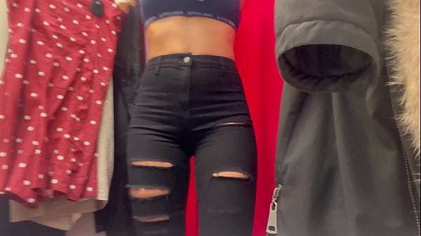 A girl tries on a dress in a public place